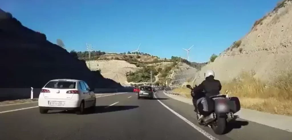 El BOE publica las nuevas normas de la DGT para motos: arcén a 30 km/h y equipamiento obligatorio 1 Motor16 2025. Moto circulando por el arcén. Scooter. DGT. Imagen.