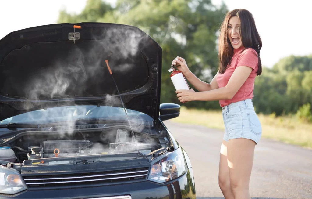 Averías por calor en el coche: la revisión en el taller que te ahorra una factura de 300 euros 1 Motor16 2025 Coche averiado. Conductora. Capó. Humo. Imagen portada.