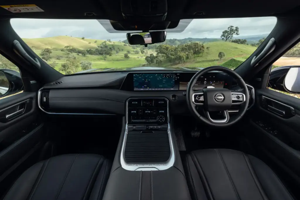 El nuevo Nissan Patrol Y63 ya tiene precio en Australia 16 Motor16 A wide dash of the all-new Nissan Patrol with rolling green hills seen through the windscreen.