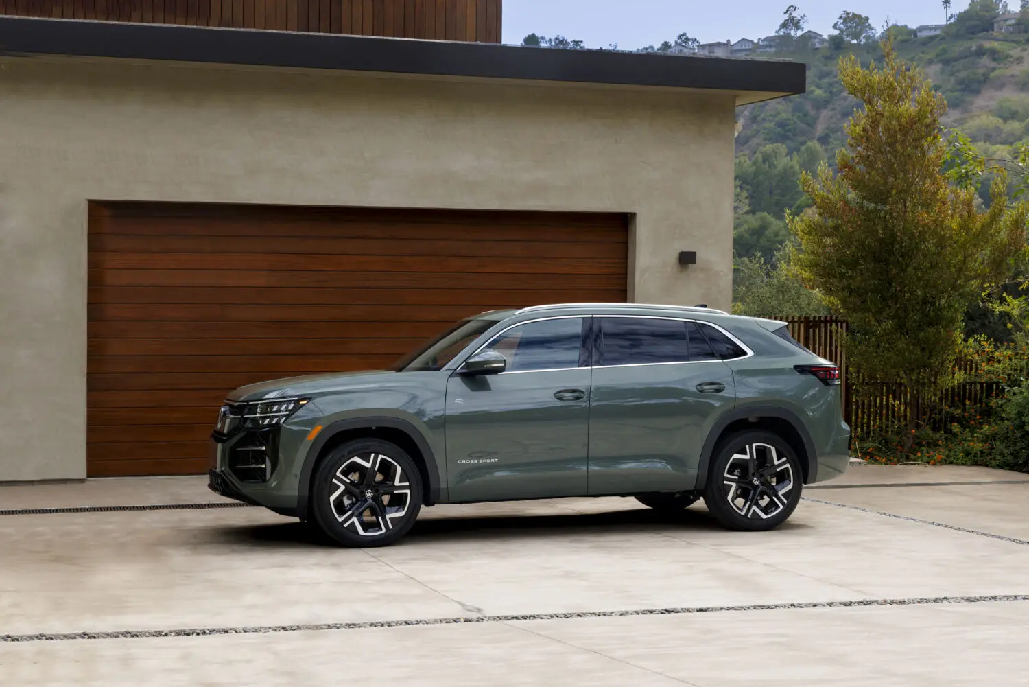 Volkswagen ha presentado el Volkswagen Atlas Cross Sport 2027, segunda generación de su SUV de cinco plazas destinado al mercado de Estados Unidos. La presentación ha tenido lugar desde la sede de Volkswagen of America en Reston (Virginia, EE. UU.), y el vehículo ha sido confirmado para su lanzamiento a principios de 2027 con especificaciones y precios que se darán a conocer antes de esa fecha. El Atlas Cross Sport se puso a la venta por primera vez en 2020 como variante de cinco plazas del Atlas de siete asientos, respondiendo a la creciente demanda del segmento de SUV con línea de techo inclinada en Estados Unidos. Desde entonces, la familia Atlas ha acumulado más de 220.000 unidades vendidas en ese mercado. El Volkswagen Atlas Cross Sport 2027 estrena una carrocería completamente nueva La segunda generación llega con carrocería completamente nueva. William Lee, diseñador exterior del modelo, describe la propuesta así: “La cabina es baja y el voladizo trasero, corto, lo que da al coche una postura muy deportiva. Las proporciones y el uso de molduras en color carrocería elevan su aspecto a la categoría superior”. Frente al Atlas de siete plazas, el Atlas Cross Sport 2027 es 13,7 cm más corto —con una longitud total de 496,8 cm— y 5,3 cm más bajo, gracias al característico pilar trasero de corte cupé. En la parte delantera, unos faros LED ubicados a doble altura, una parrilla superior enmascarada y un capó de trazado marcado componen la nueva cara del modelo. Los acabados no básicos incorporan dobles líneas luminosas y un emblema VW iluminado. En la parte trasera, los pilotos cruzan la anchura del vehículo en un solo trazo y quedan a ras del paragolpes trasero, mientras los intermitentes de bienvenida y despedida son de serie. Las llantas de aleación en acabados mecanizado y negro pasan a 20 y 21 pulgadas (508 y 533 mm) en los acabados superiores; la versión de acceso monta llantas de 18 pulgadas (457 mm). Se añaden tres nuevos colores: Dark Sage Metallic, Blackberry Metallic y Sandstone. Llega el motor más potente de la saga al Volkswagen Atlas Cross Sport El Volkswagen Atlas Cross Sport 2027 estrena la versión evo5 del motor EA888 TSI, un cuatro cilindros de 2,0 litros con turbocompresor de geometría variable que desarrolla 286 CV (282 hp) y 350 Nm de par (258 lb-ft). Según Volkswagen, este propulsor representa un incremento de 13 hp (13 CV) sobre el anterior y, pese a ello, la marca anticipa una mejora en el consumo de combustible. La transmisión es automática de ocho velocidades con función Tiptronic. La tracción delantera es de serie, y el sistema de tracción integral 4Motion está disponible en toda la gama. La capacidad de remolque se mantiene en 2.268 kg (5.000 lb) para los modelos con enganche de fábrica. Volkswagen anuncia una variante híbrida que llegará más adelante. El habitáculo adopta un nuevo elemento arquitectónico en forma de arco que unifica el salpicadero en un trazo continuo. La pantalla de infoentretenimiento es de 12,9 pulgadas en la versión de acceso y de 15 pulgadas en el 90 % de los acabados. El cuadro de instrumentos es digital, de 10,25 pulgadas, configurable, y se suma un nuevo mando selector Driver Experience Dial para el volumen, los modos de conducción y los ajustes de iluminación ambiental. La consola central incorpora carga inalámbrica Qi2 para dos dispositivos simultáneos y cinco puertos USB-C. Los asientos delanteros se han revisado con reglaje eléctrico de doce vías y soporte lumbar de cuatro vías de serie. Los acabados superiores añaden soporte para los muslos y función de masaje tanto para el conductor como para el pasajero delantero. La función de portón trasero automático con apertura Easy Open, los parasoles traseros y el control de aparcamiento delantero y trasero son de serie en toda la gama. El techo panorámico sigue disponible en la mayoría de los acabados. En materia de conectividad, a partir del año modelo 2027, los servicios vinculados a la plataforma myVW+ se agrupan en una suscripción única denominada In-Vehicle Premium, que incluye navegación en tiempo real, radio de más de 30.000 emisoras, punto de acceso wifi para hasta cuatro dispositivos y la plataforma de videojuegos AirConsole, entre otras funciones. El paquete de asistencia a la conducción IQ.DRIVE incorpora mejoras notables: el sistema Travel Assist —conducción semiautomatizada con las manos en el volante— amplía su rango hasta 153 km/h (95 mph) e incorpora el cambio de carril a iniciativa del conductor. La función Emergency Assist Plus puede guiar el vehículo hasta el arcén si detecta una emergencia médica. El crucero adaptativo predictivo (pACC) ajusta la velocidad en función del trazado de la ruta en los dos acabados superiores. El Volkswagen Atlas Cross Sport 2027 se ensambla en la planta de Chattanooga (Tennessee, EE. UU.), donde Volkswagen emplea a cerca de 4.000 personas. La familia Atlas en su conjunto representa alrededor de un tercio de las ventas de Volkswagen en Estados Unidos. El modelo no está previsto para el mercado europeo, donde su equivalente funcional más próximo sería el Volkswagen Tiguan, de similar arquitectura pero con una carrocería más compacta. Las claves del Volkswagen Atlas Cross Sport 2027 Segunda generación del SUV de cinco plazas de Volkswagen para el mercado norteamericano, con carrocería totalmente nueva. Motor TSI EA888 evo5 de 2,0 litros y 286 CV (282 hp), el más potente montado en un Atlas Cross Sport. Par máximo de 350 Nm (258 lb-ft) y transmisión automática de ocho velocidades; tracción integral 4Motion disponible en toda la gama. Pantallas de infoentretenimiento de hasta 38,1 cm (15 pulgadas) y sistema de conectividad myVW+ con suscripción unificada. Sistema Travel Assist actualizado hasta 153 km/h (95 mph) con cambio de carril a iniciativa del conductor. Capacidad de remolque de 2.268 kg (5.000 lb) con enganche de fábrica; variante híbrida prevista para la actualización de ciclo medio. Fabricación en la planta de Chattanooga (Tennessee, EE. UU.); precios y especificaciones definitivos se anunciarán antes del lanzamiento a principios de 2027.